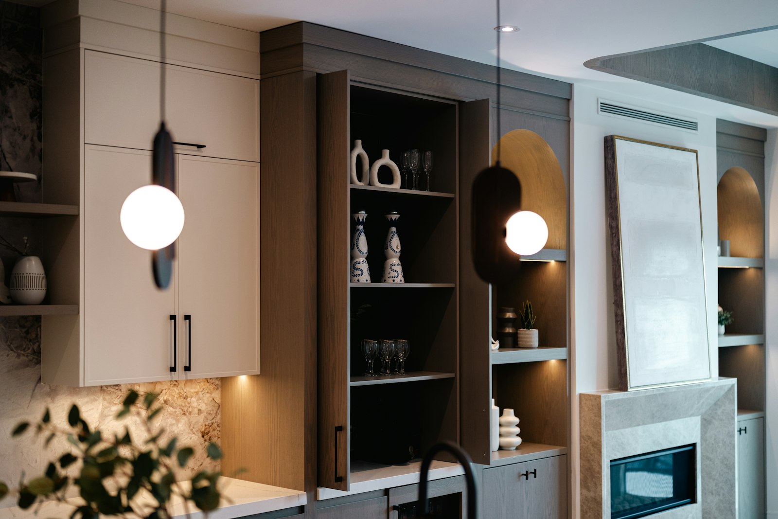 Modern kitchen with open shelving and pendant lights.
